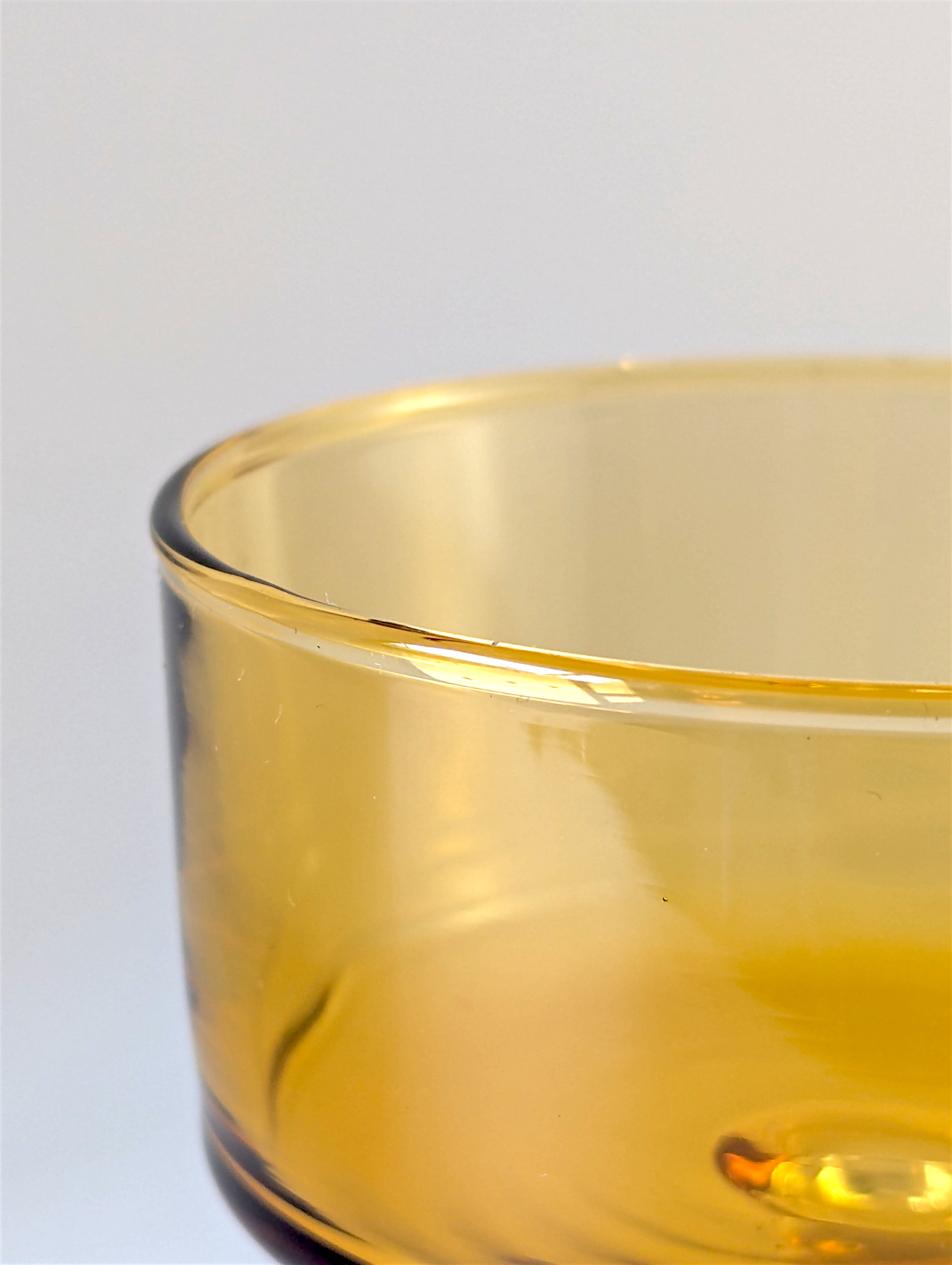 Close-up of a yellow glass bowl on a light gray background