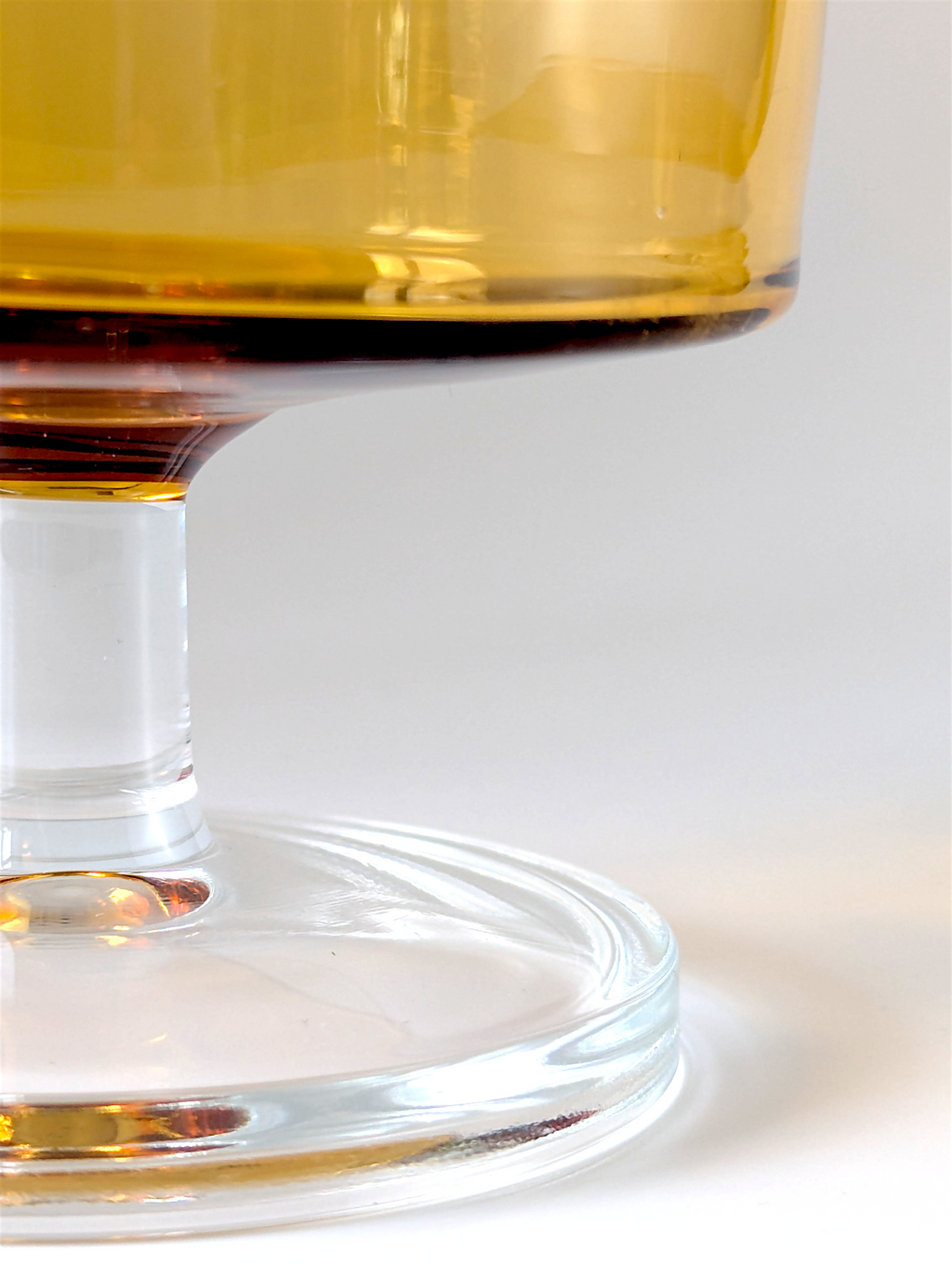 Close-up of a glass filled with a amber-colored liquid on a white background