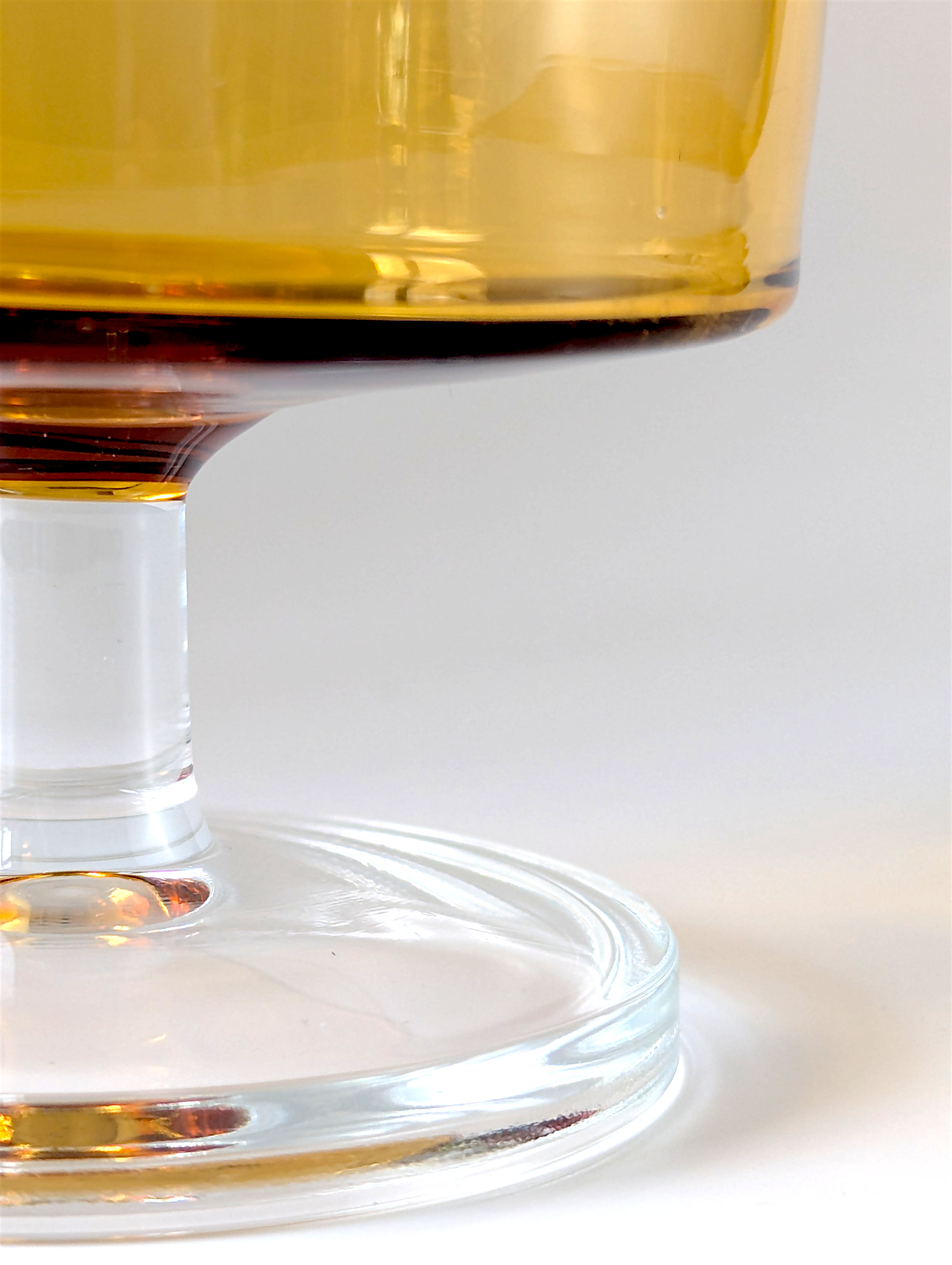 Close-up of a glass filled with a amber-colored liquid on a white background